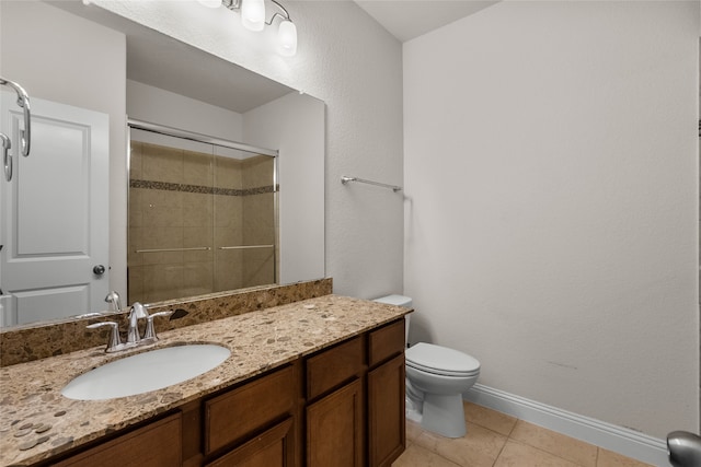 bathroom featuring toilet, walk in shower, vanity, and tile patterned floors