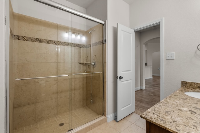 bathroom featuring a shower with door, vanity, and hardwood / wood-style floors