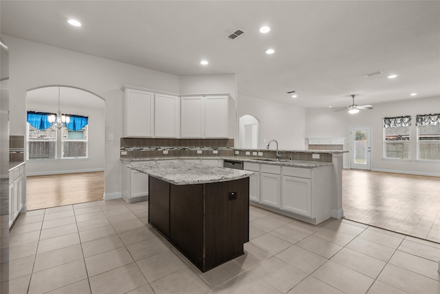 kitchen with white cabinetry, a healthy amount of sunlight, a center island, and sink