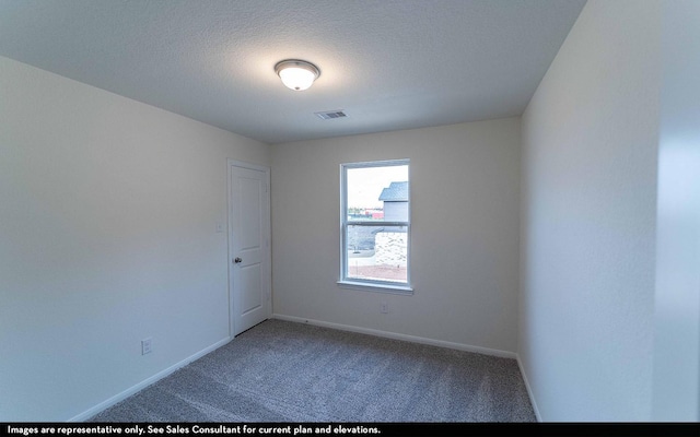 carpeted empty room with a textured ceiling