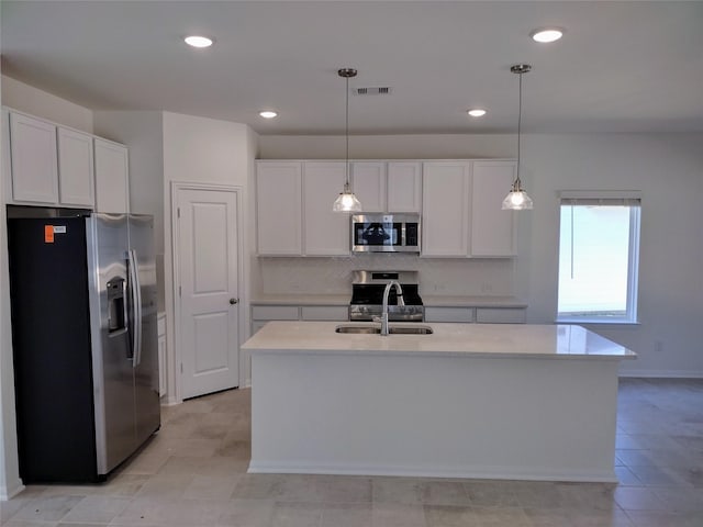 kitchen featuring white cabinetry, appliances with stainless steel finishes, and a center island with sink