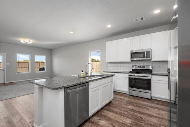 kitchen with sink, an island with sink, stainless steel appliances, white cabinets, and dark hardwood / wood-style floors