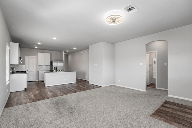 unfurnished living room with dark colored carpet