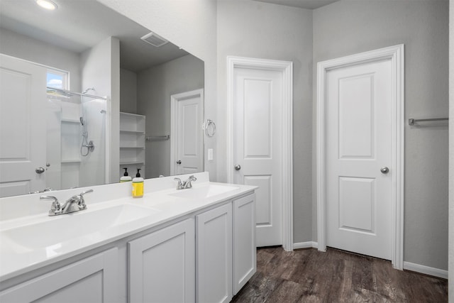 bathroom featuring vanity, a shower, and wood-type flooring