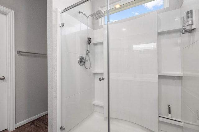 bathroom with a shower with door and hardwood / wood-style floors