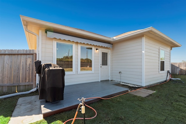 rear view of property featuring a wooden deck and a yard