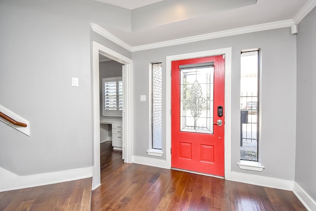 foyer with built in desk, ornamental molding, and dark hardwood / wood-style flooring