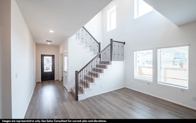 foyer entrance featuring light hardwood / wood-style floors and a towering ceiling