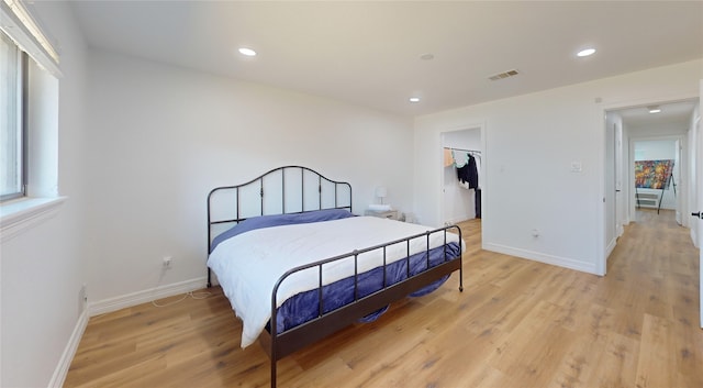 bedroom with a spacious closet, a closet, and light wood-type flooring