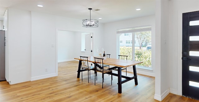 dining space with an inviting chandelier and light hardwood / wood-style floors