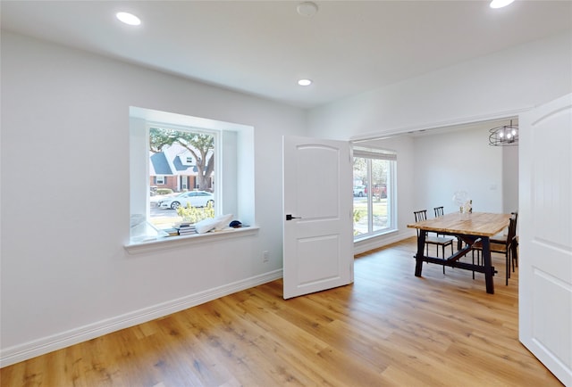 office space with light hardwood / wood-style flooring and an inviting chandelier