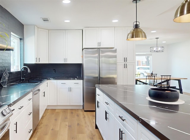 kitchen featuring decorative backsplash, white cabinetry, and stainless steel appliances