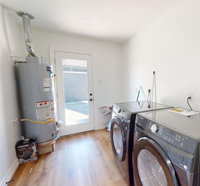 laundry room with water heater, independent washer and dryer, and light wood-type flooring