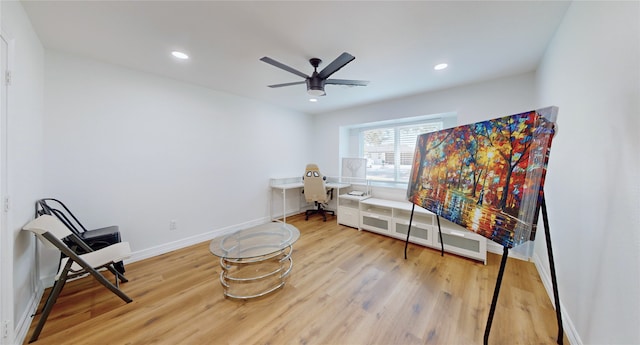 living area with hardwood / wood-style flooring and ceiling fan