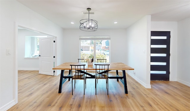 dining area featuring light hardwood / wood-style flooring and an inviting chandelier