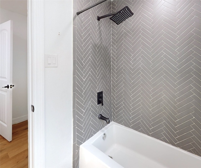 bathroom featuring tiled shower / bath combo and hardwood / wood-style floors