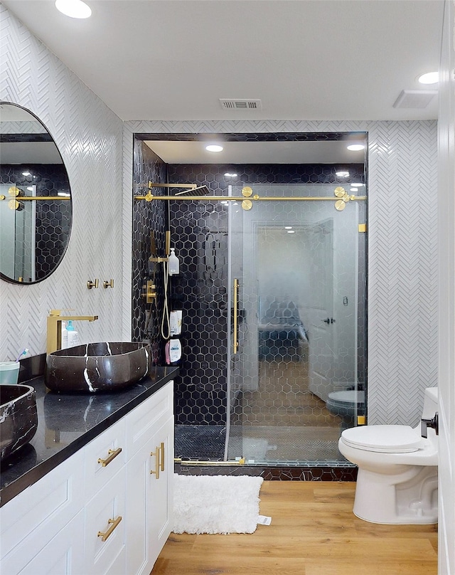 bathroom with toilet, an enclosed shower, vanity, and wood-type flooring