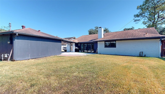 rear view of property with a patio and a yard