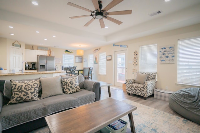 living room with light wood-type flooring and ceiling fan