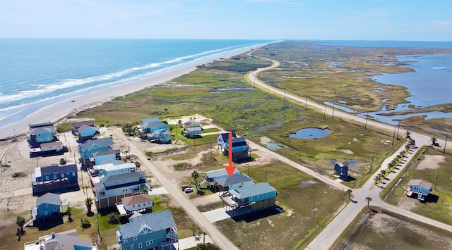 birds eye view of property with a water view and a beach view