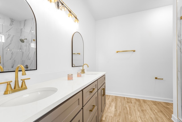 bathroom with vanity, wood-type flooring, and tiled shower