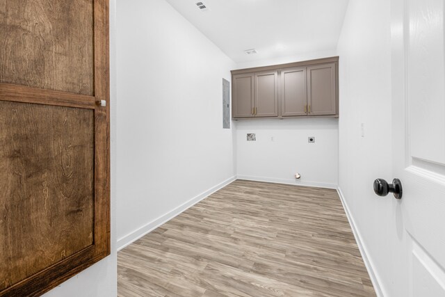 clothes washing area with light hardwood / wood-style flooring, electric panel, cabinets, and hookup for an electric dryer