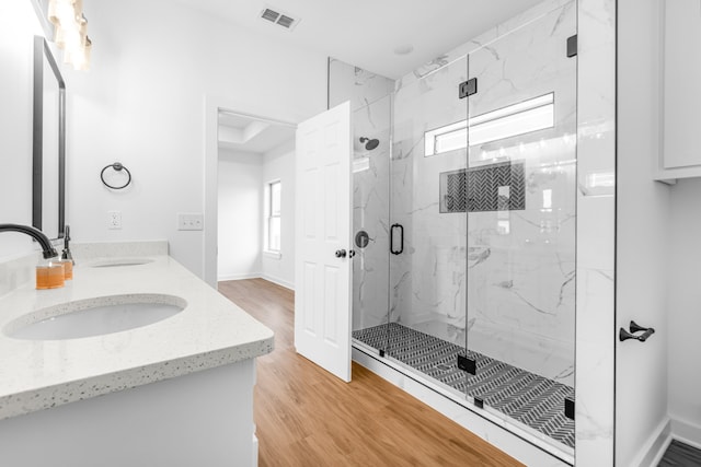 bathroom featuring vanity, wood-type flooring, and walk in shower