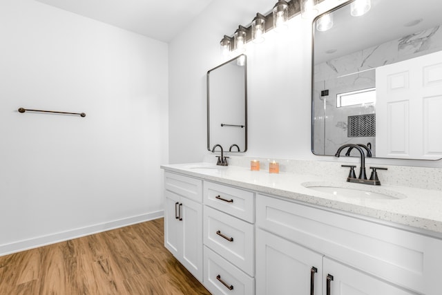 bathroom with hardwood / wood-style floors, vanity, and walk in shower