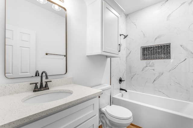 full bathroom featuring tiled shower / bath combo, toilet, and vanity