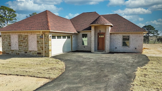 french country home featuring a garage