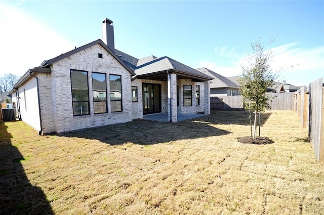 back of property with central AC, a yard, and a patio