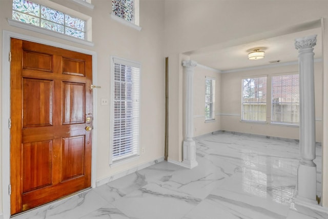 entryway featuring crown molding, plenty of natural light, and decorative columns