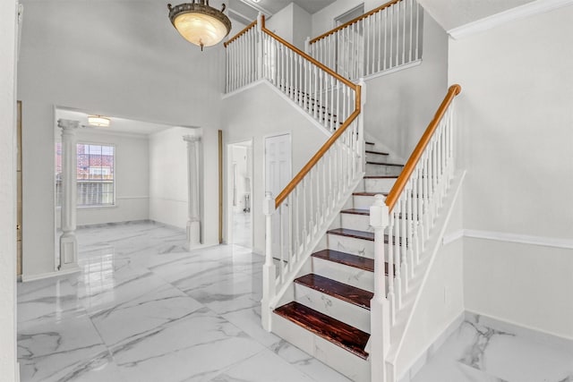 staircase with a high ceiling and ornamental molding