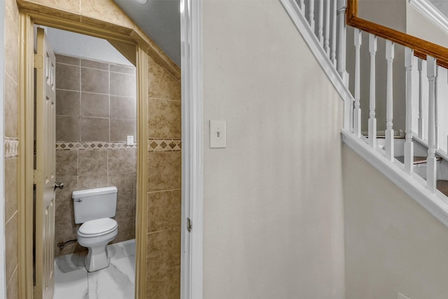 bathroom with vaulted ceiling, tile walls, and toilet