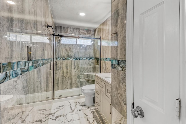 bathroom featuring vanity, toilet, and a shower with shower door