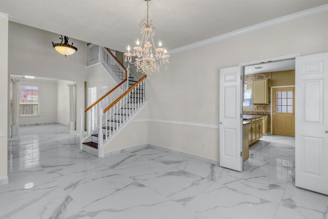 entrance foyer with crown molding and a chandelier