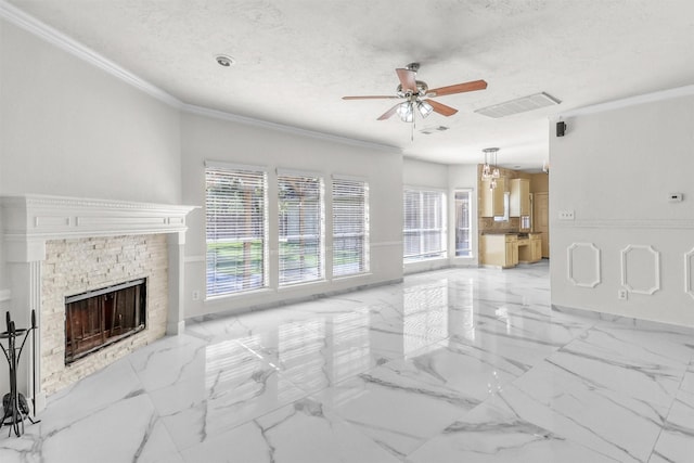 unfurnished living room with ceiling fan, crown molding, a fireplace, and a textured ceiling