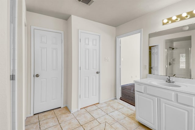 bathroom featuring walk in shower, tile patterned floors, and vanity