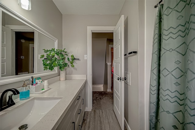 bathroom featuring vanity, wood-type flooring, and walk in shower