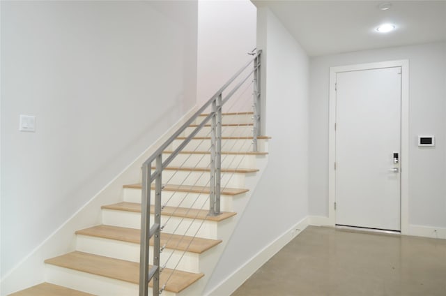 stairway featuring concrete floors