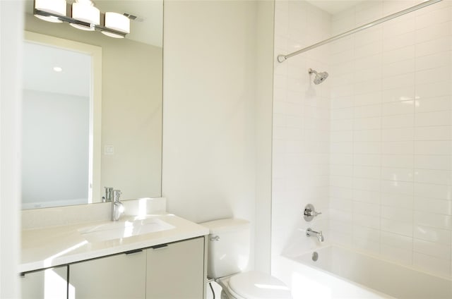 full bathroom featuring vanity, tiled shower / bath combo, and toilet