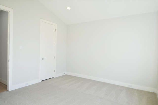 carpeted spare room featuring lofted ceiling