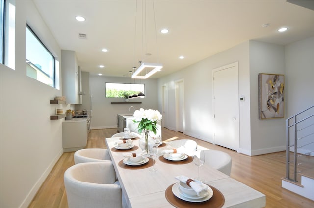 dining area featuring light wood-type flooring and sink