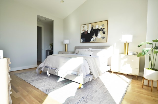 bedroom featuring light hardwood / wood-style flooring and lofted ceiling