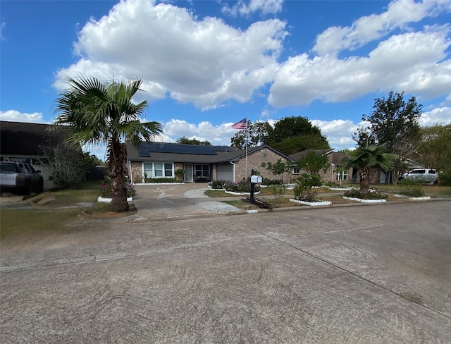 15810 Amapola Dr, Houston, TX 77083 - ranch-style home featuring concrete driveway, roof mounted solar panels, and a garage