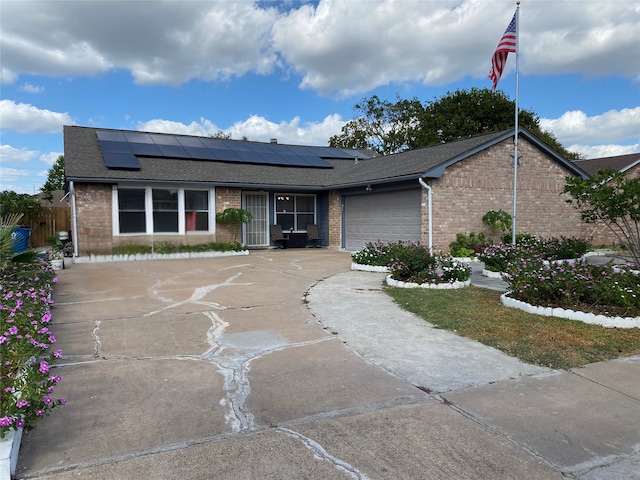 ranch-style house featuring solar panels and a garage