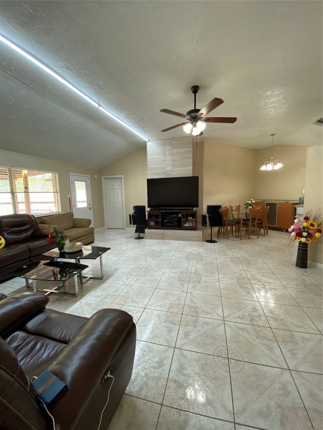 living room with vaulted ceiling, a textured ceiling, ceiling fan with notable chandelier, and light tile patterned floors