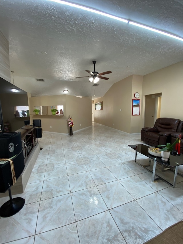 tiled living room featuring vaulted ceiling, a textured ceiling, and ceiling fan