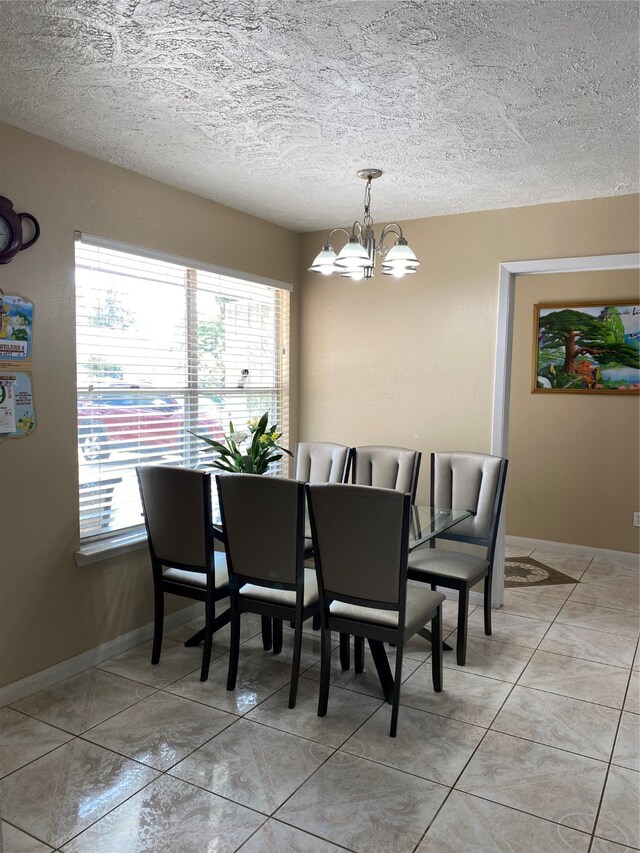 tiled dining area with a textured ceiling and an inviting chandelier