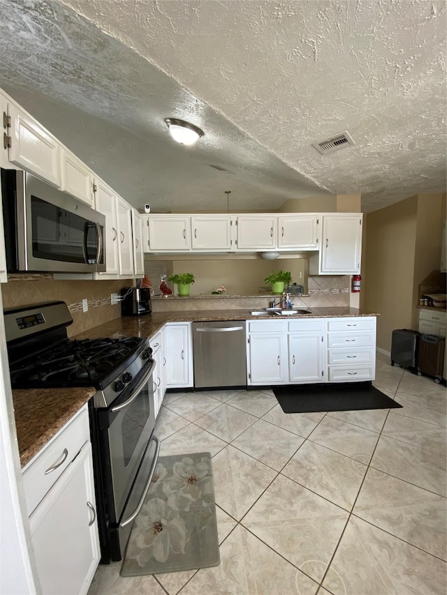 15810 Amapola Dr, Houston, TX 77083 - kitchen featuring visible vents, white cabinetry, appliances with stainless steel finishes, and tasteful backsplash